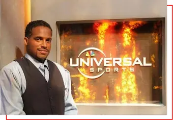 Professional man standing confidently in a television studio with the Universal Sports logo in the background — representing career growth, media opportunities, and post-career development with HSI.net.